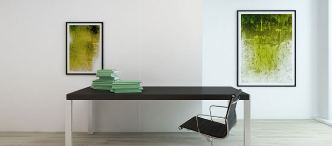 Ein äußerst übersichtliches, sauberes Büro mit weißen Wänden, welche mit zwei kunstvollen Bildern verschöner wurden. Die Bilder stellen moderne Kunst in verschiedenen Grüntönen dar.
