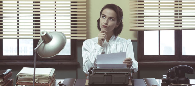 Zeitreise ... das Büro im Jahr 1969 / auf dem Foto: Eine Sekretärin, die an einer Schreibmaschine arbeitet und nachdenkt.