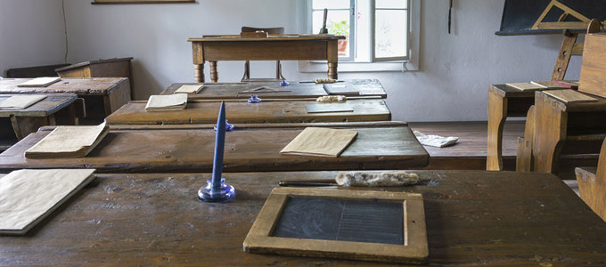 Klassentreffen / auf dem Foto: Ein altes Klassenzimmer mit Tischen, Lehrer-Pult und diversen Schulutensilien.