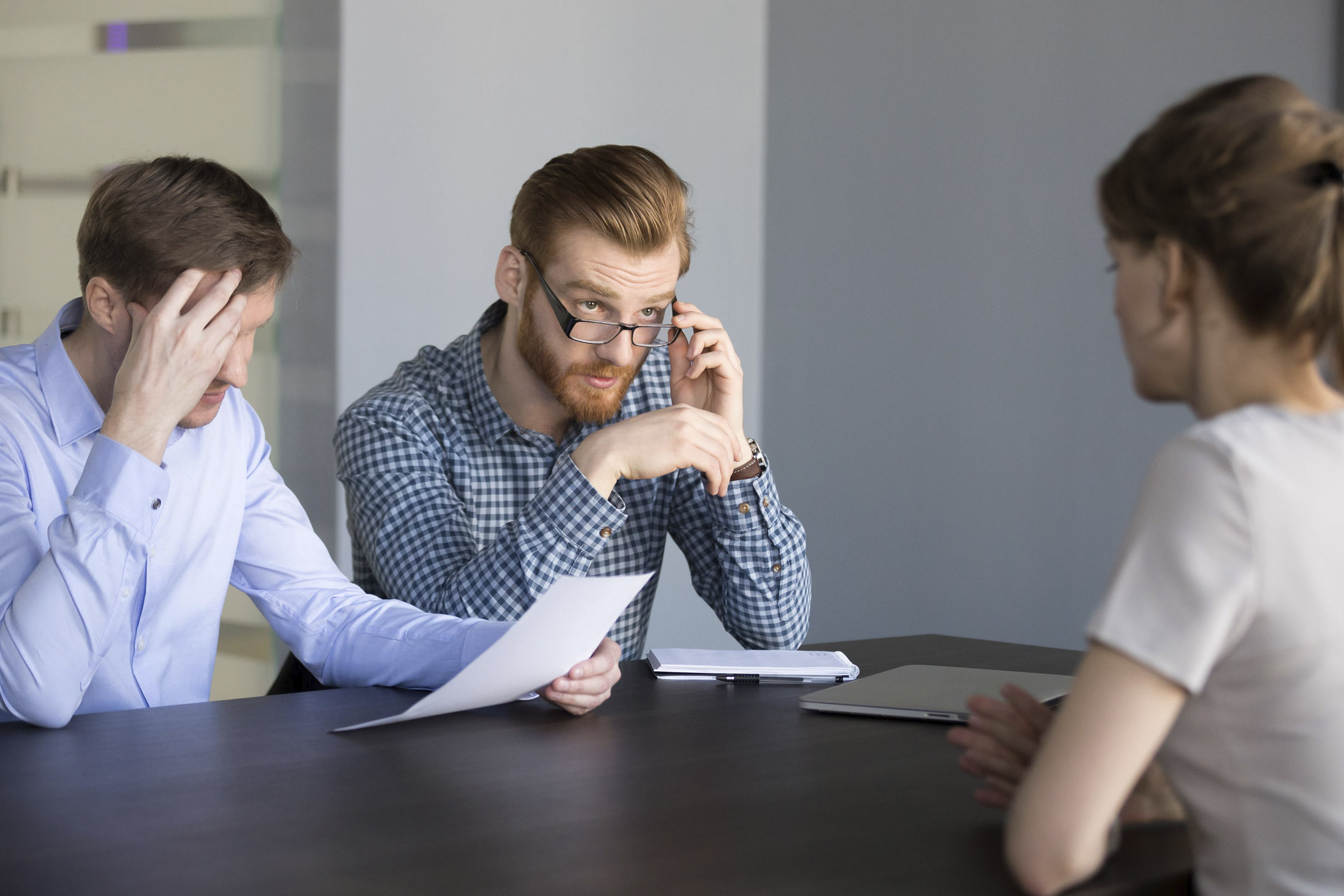 Nervosität und Aufregung können schnell zu Fehlern im Bewerbungsgespräch führen. Auf dem Foto: zwei kritische Personaler im Vorstellungsgespräch mit einer Bewerberin.