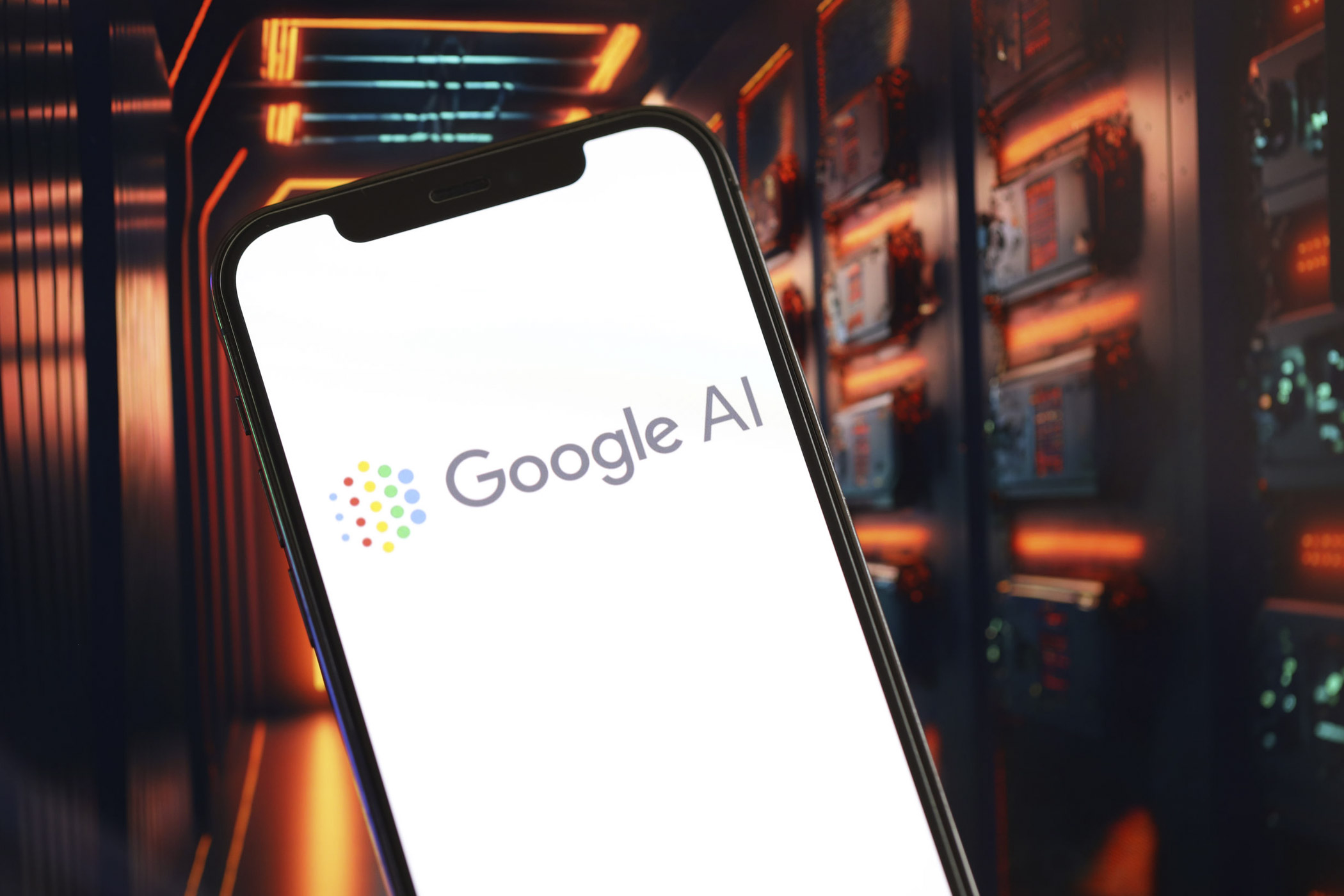 : Wie funktioniert der Google KI-Modus? / auf dem Foto: Man sieht ein Smartphone in einer Hand mit Schriftzug „Google AI“ und buntem Punktmuster auf dem Display. Symbolisch für den Google KI-Modus.